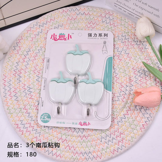 Three pumpkin - shaped sticky hooks. Sold out and then taken off the shelves.