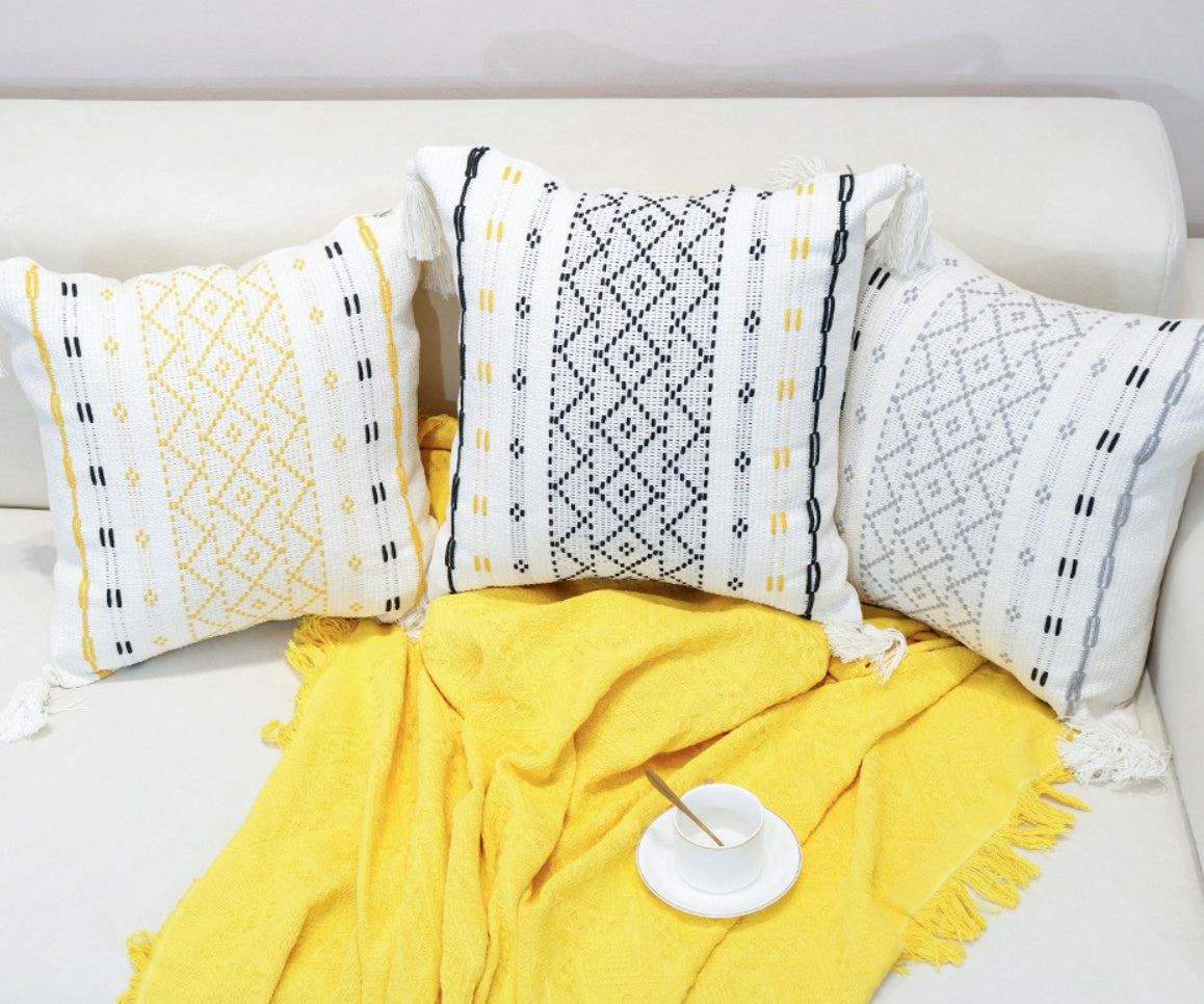 Cojín tejido con borlas y diseño de diamante